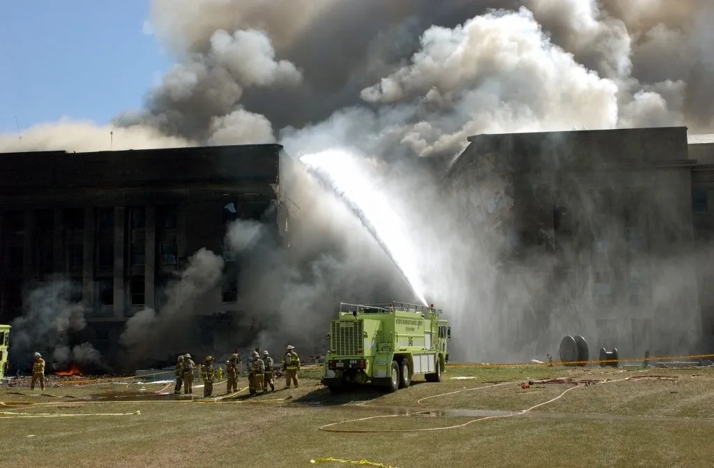 A fire truck is spraying water on the burning building.