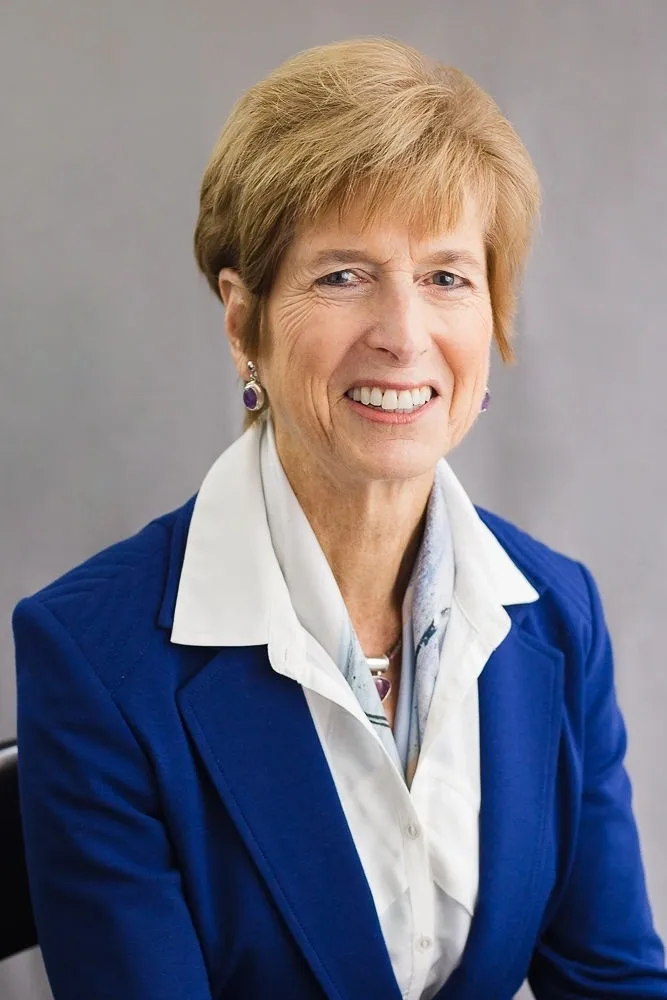 A woman in a blue jacket and white shirt