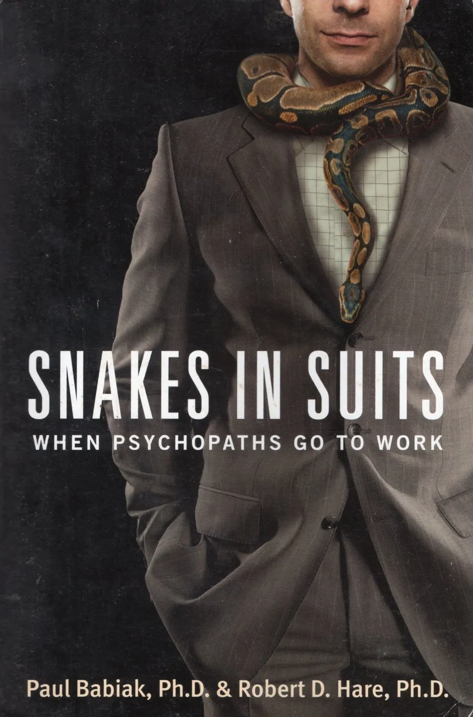 A man in a suit and tie with the words snakes in suits