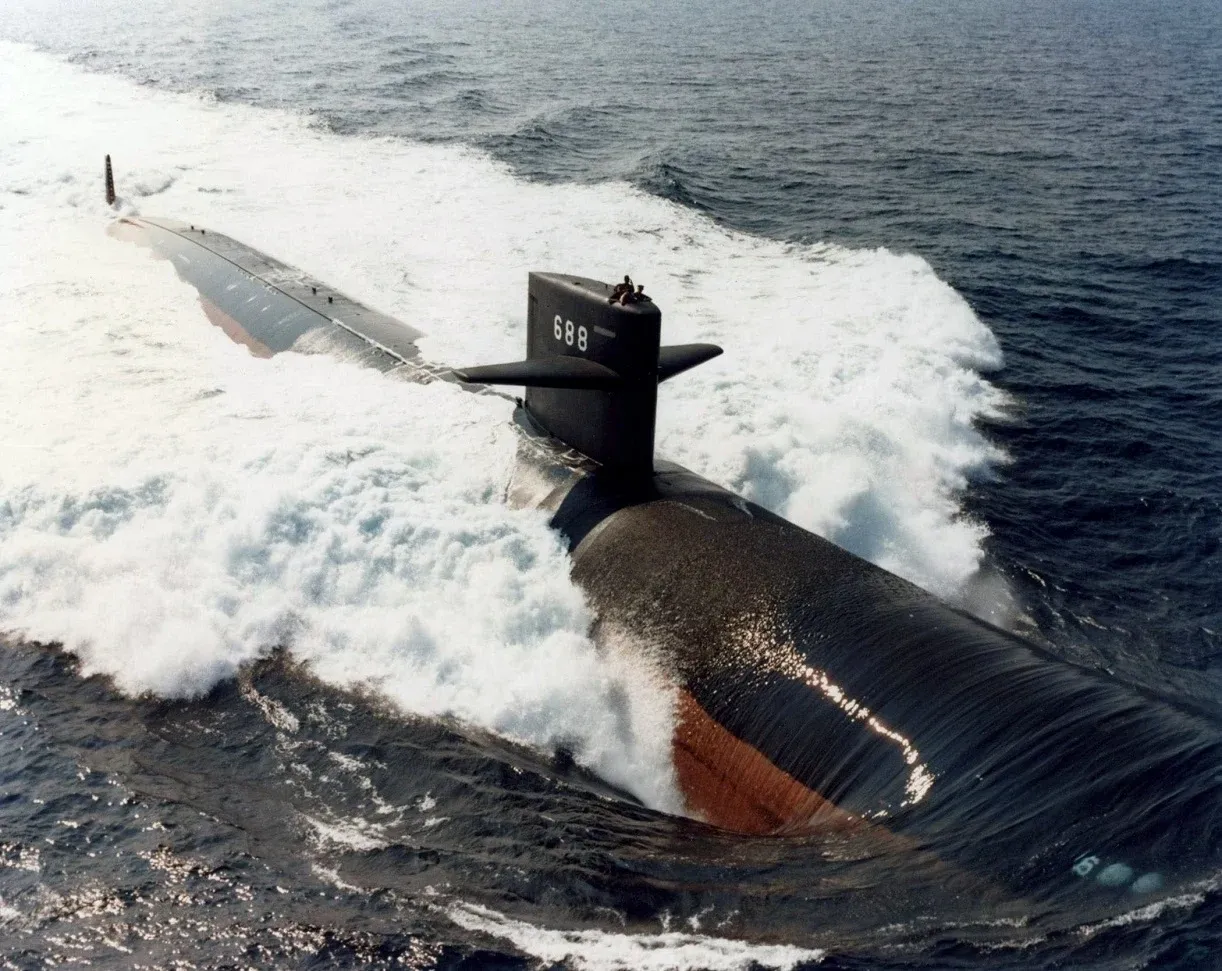 A large submarine in the ocean with waves coming out of it.