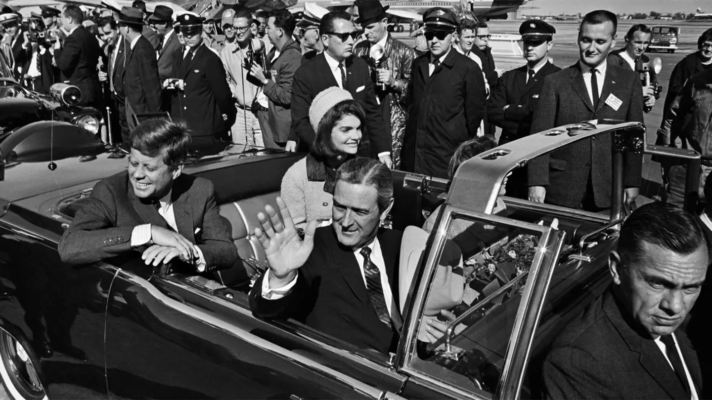 A man and woman in the back of a car.