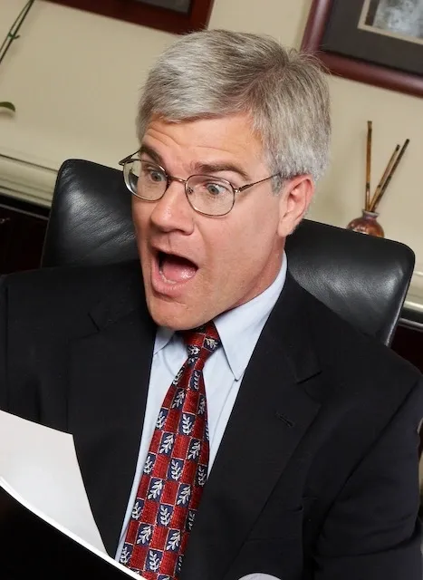 A man in a suit and tie holding papers.